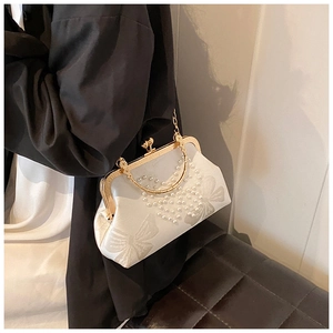 Détail d'un sac satin blanc avec broderie papillon et perles en forme de cœur élégant