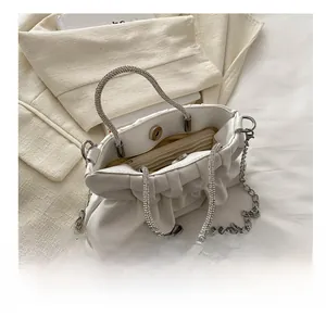 Detailweergave van de witte geplooide tas met binnenruimte en magnetische sluiting