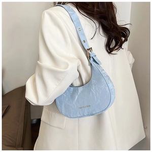 Detail of light blue pleated hobo bag showing gold eyelets and textured crescent design