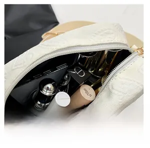 Macro view of white embossed floral pattern makeup bag showing spacious interior storage