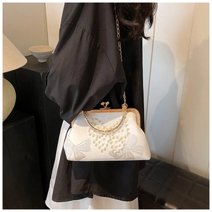 Detail of white satin evening bag with pearl floral accents and gold metal clasp