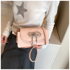 Close-up of pink square crossbody bag featuring a sparkling crystal bow decoration