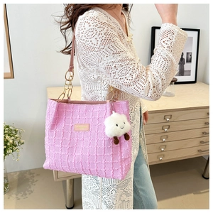 Pink tweed tote bag detail with gold chain strap and cute cloud charm in home setting