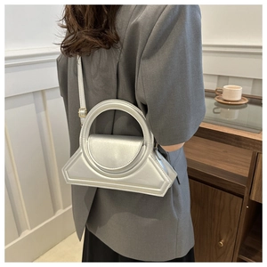 Borsa geometrica argento con manico rotondo abbinata a un blazer professionale grigio