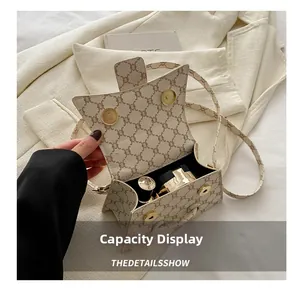 Interno della borsa a tracolla beige con spazio per rossetto e polvere compatta