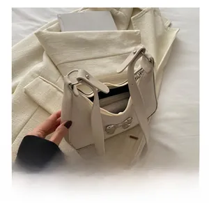 Detail view of cream-colored bow shoulder bag interior showing daily storage capacity
