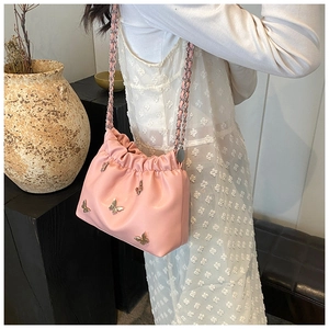 Detail der rosa Leder-Beuteltasche mit silbernen Metallschmetterlingen und Kettenriemen