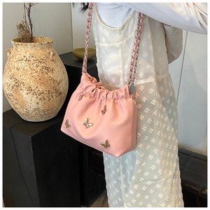 Details der rosa Eimertasche aus Kunstleder mit goldenen Schmetterlingen und Kettenriemen
