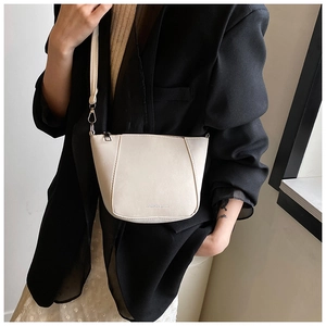Dettaglio della borsa a secchiello crema minimalista con stampa fashion e ganci in metallo