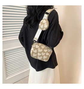 Detail of khaki crossbody bag set with white heart patterns and wide shoulder strap