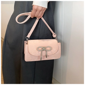 Detail shot of the pink suede shoulder bag with a sparkling rhinestone bow decoration