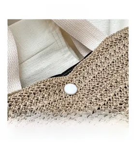 Détails macro du sac cabas tissé beige montrant la texture, la boucle blanche et la doublure