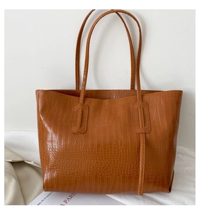 Détail du sac cabas marron caramel avec texture crocodile brillante et longues lanières