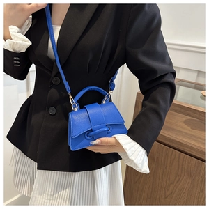 Dettaglio mini borsa blu con trama a grana e silhouette curva con tracolla sottile