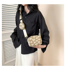 Detail of khaki heart canvas crossbody bag with wide strap and matching round coin purse