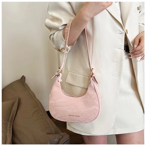 Close-up of pink crescent underarm bag with pleated texture and fashion branding
