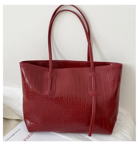 Détail d'un grand sac cabas bordeaux avec un motif embossé crocodile brillant