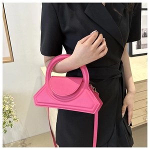 Dettaglio borsa a trapezio rosa acceso con manico integrato e finitura opaca