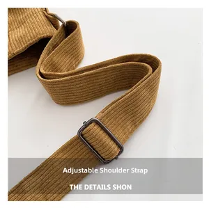 Detailed macro view of adjustable corduroy shoulder strap with metal buckle hardware