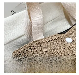 Gros plan du sac fourre-tout en paille tressée avec texture épaisse et détails de bandoulière
