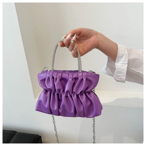 Detail of purple pleated cloud bag featuring a diamond-encrusted silver handle and chain