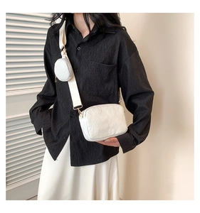 Detail of white PU crossbody bag with heart embossing and mini coin purse attachment