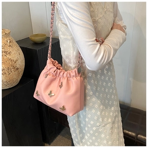 Schicke rosa Falten-Beuteltasche mit Metall-Schmetterlingen und Kettenriemen am Modell