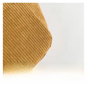 Macro shot of ginger yellow corduroy fabric showing thick vertical ribbed texture