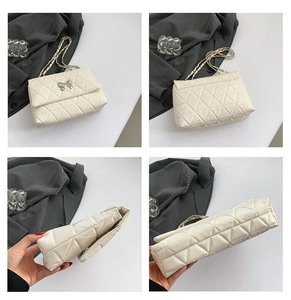Detail view of cream quilted chain bag showing stitching, metal bow clasp, and structure