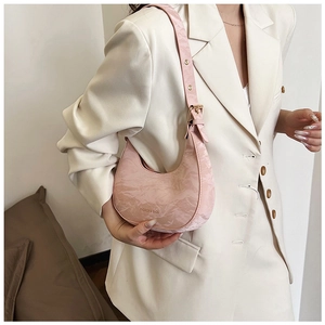 Close-up of pink pleated crescent bag with gold-tone fashion text and metal buckle