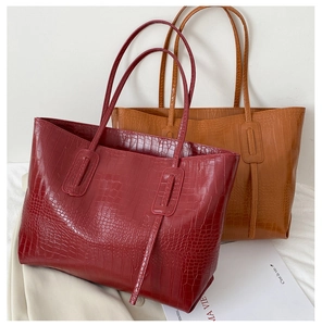 Détails de la texture crocodile sur les grands sacs cabas bordeaux et marron clair