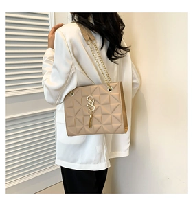 Close-up of apricot chain bag featuring SS logo and triangle quilted leather detail