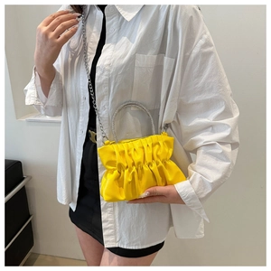 Detail of bright yellow pleated crossbody bag with a sparkling rhinestone handle