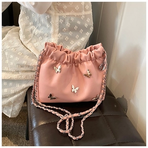 Detail der rosa Kordelzug-Beuteltasche mit Schmetterlingsakzenten und Kettenriemen