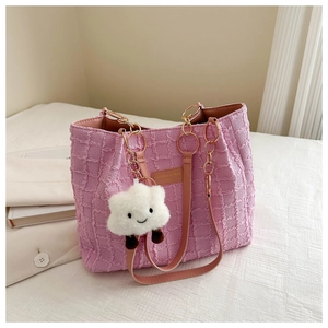 Detail of pink pleated tote bag with golden chain strap and a cute cloud charm