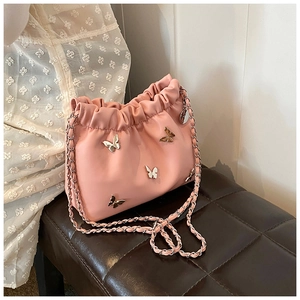 Detail der rosa gerafften Beuteltasche mit Metallschmetterlingen und geflochtener Kette