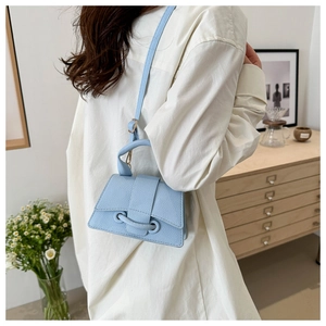 Vista posteriore di una mini borsa a tracolla in pelle azzurra con motivo litchi su modella