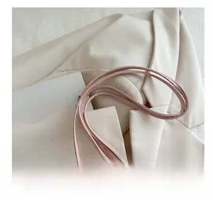 Detail view of pink pleated handbag showing soft leather folds and thin cord shoulder straps