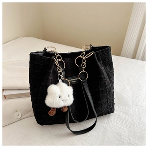 Detail of black textured tote bag with gold chain strap and cute cloud charm