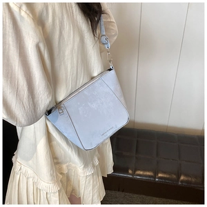 Dettaglio borsa a secchiello celeste in pelle con scritta moda e tracolla regolabile