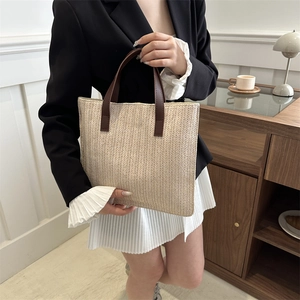 Minimalist woven tote bag with brown leather handles and V-shape straw pattern