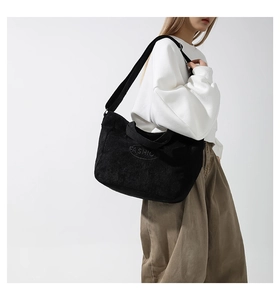 Detail shot of black corduroy tote bag with fashion embroidery and wide shoulder strap