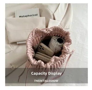 Pink pleated bucket bag interior showing capacity for phone, wallet and umbrella