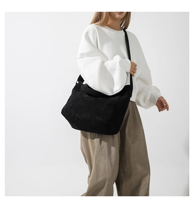 Detail of black corduroy shoulder bag with FASHION embroidery and adjustable strap