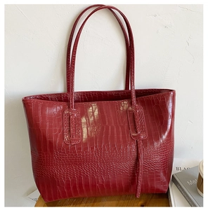 Vue détaillée du motif crocodile rouge foncé sur ce sac cabas en similicuir brillant