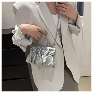 Zilveren geplooide cloud bag met strass handvat en ketting gedragen door model