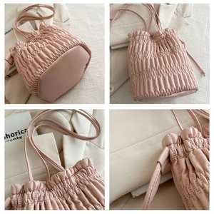 Detail shots of pink pleated drawstring bucket bag with soft PU leather and ruched texture