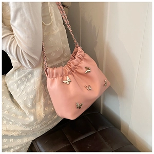 Detailansicht der rosa Beuteltasche mit silbernen Metallschleifen und Kettenriemen