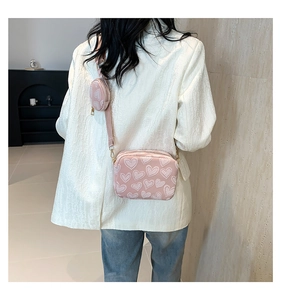 Pink heart-patterned canvas crossbody bag with adjustable strap and small round pouch