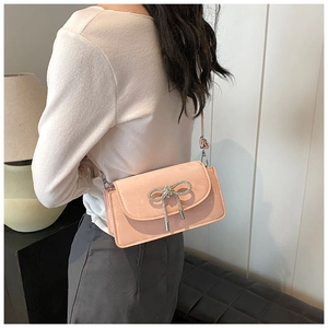 Pink bow square bag featuring textured suede finish and sparkling diamond accents